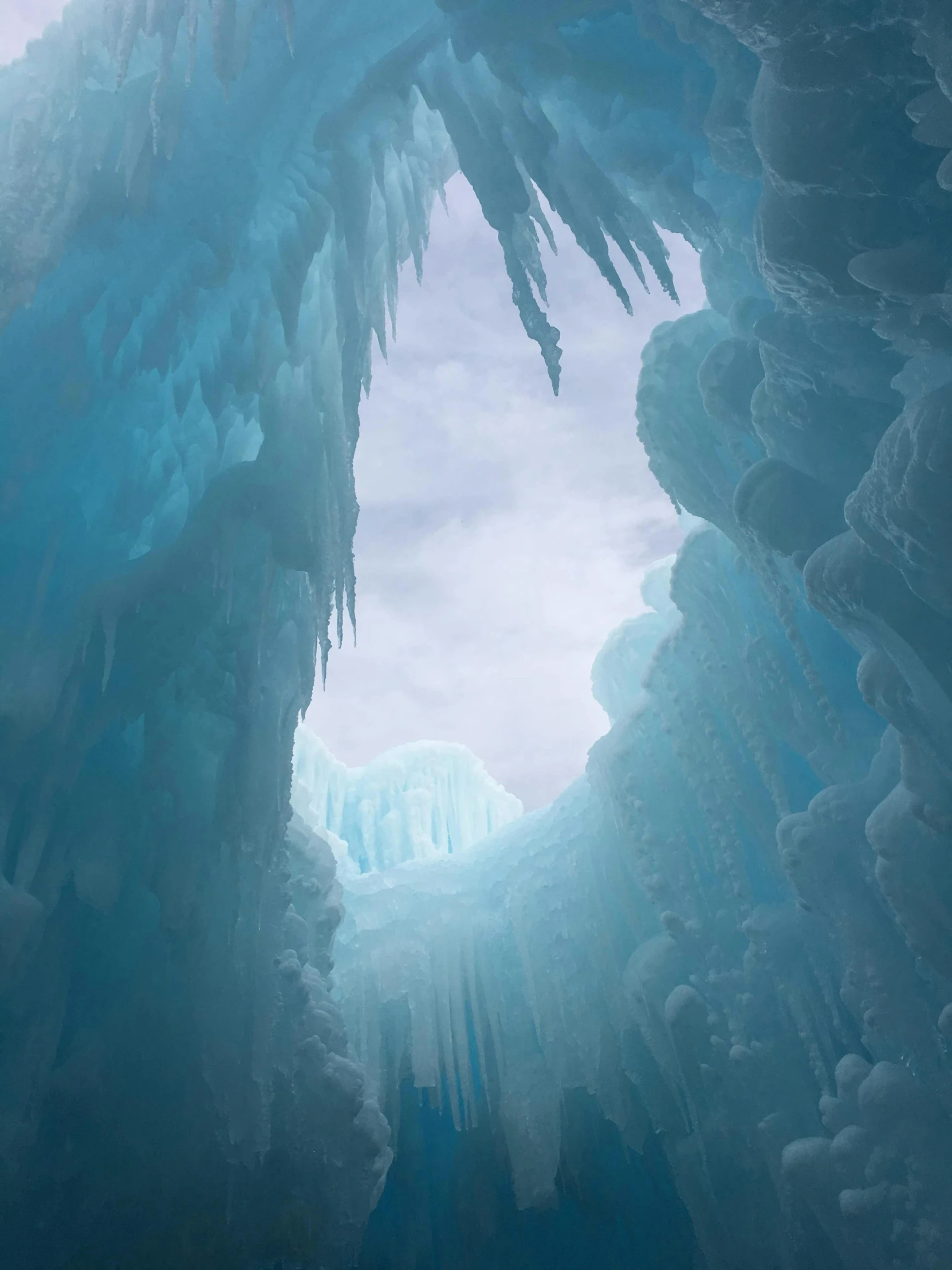 a person in the middle of a blue ice cave