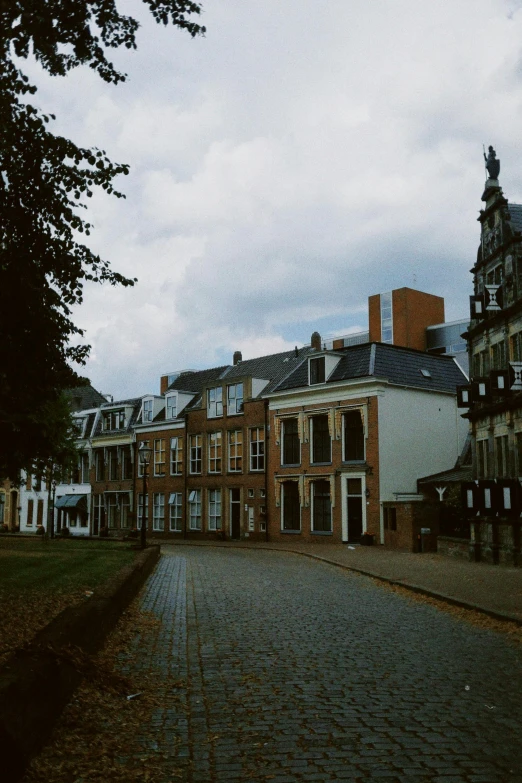 a brick street that has a row of large buildings