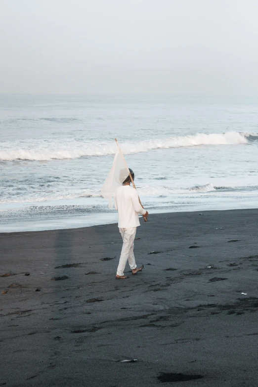 a person walking across the beach on the other side of the ocean