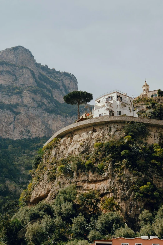 the white building on top of the hill with the mountain behind it