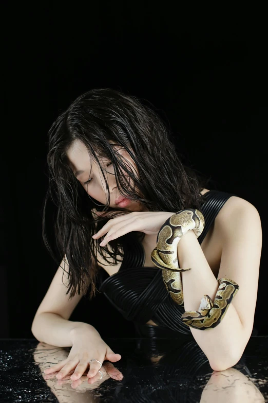 woman in a black and gold dress on a table