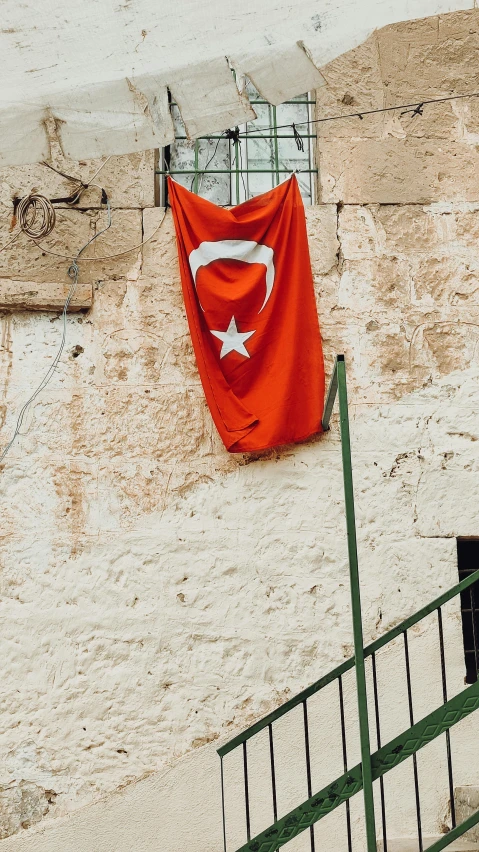 a red flag hanging on the side of a building