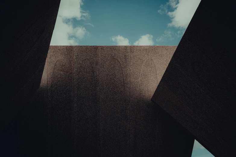 a large, abstract sculpture with two triangulars in front of the sky