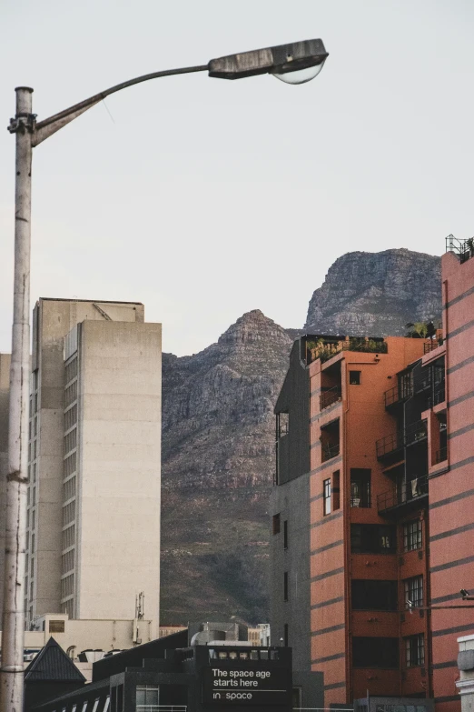 a building with mountains in the background under a light pole