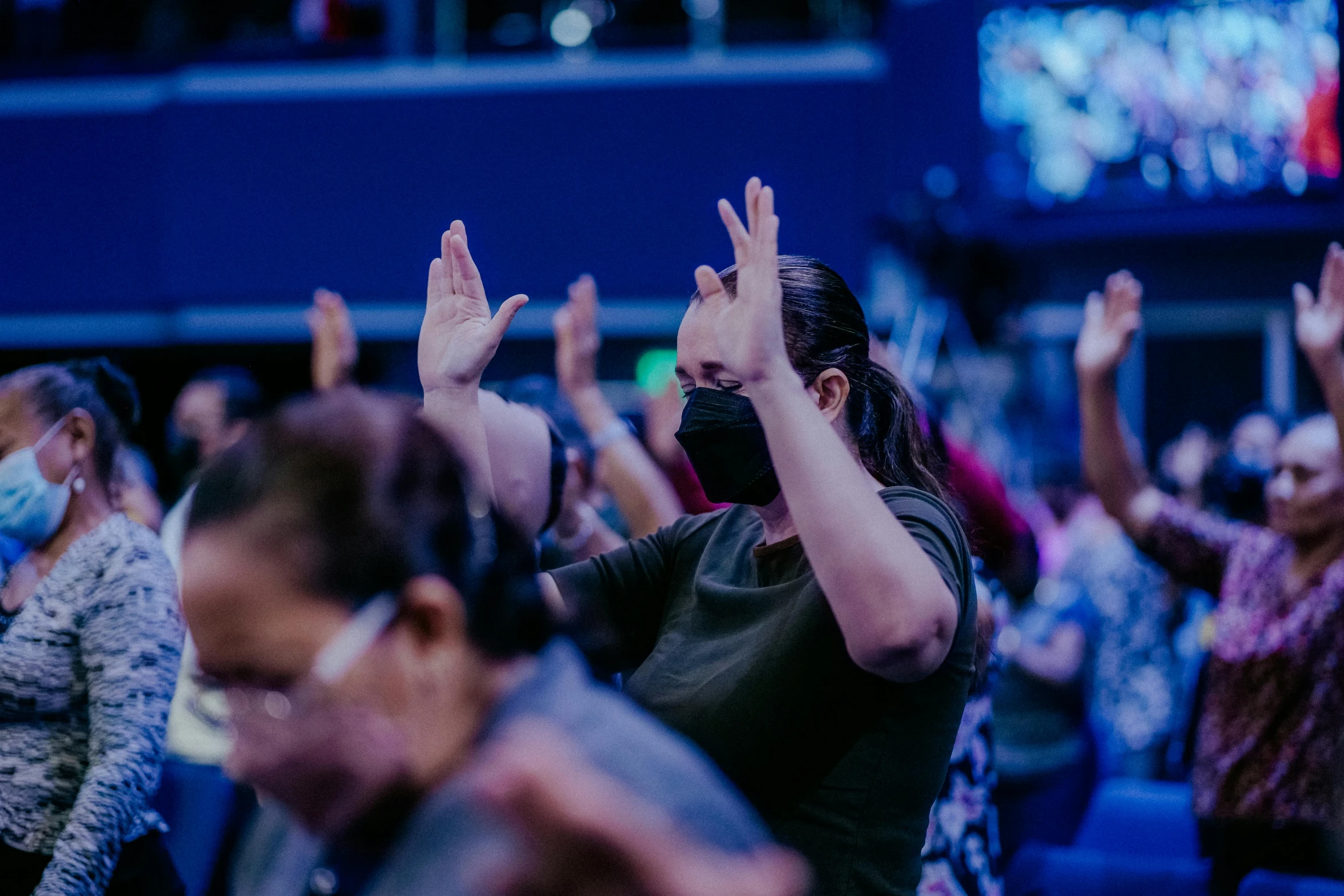 a crowd of people who are waving their hands