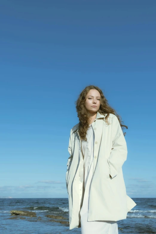 a woman is standing on the beach near the ocean