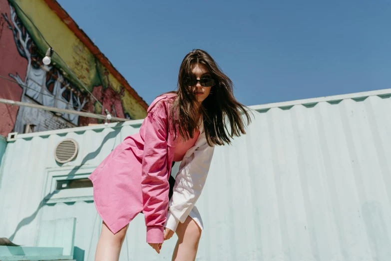 a woman wearing sunglasses holding onto a skateboard