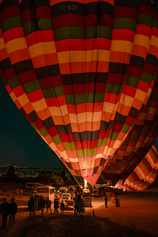 many people in the background watching colorful  air balloons