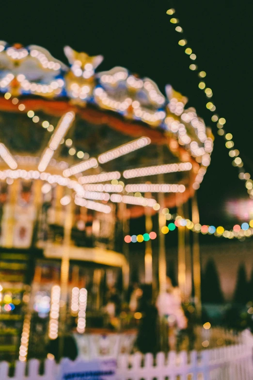 a merry go round is lit up with colorful lights