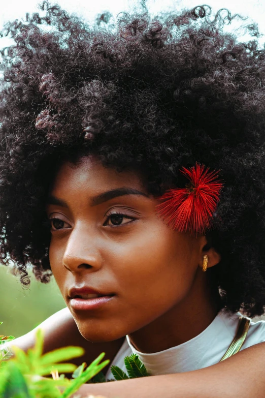 woman with a big afro with red flowers on her hair