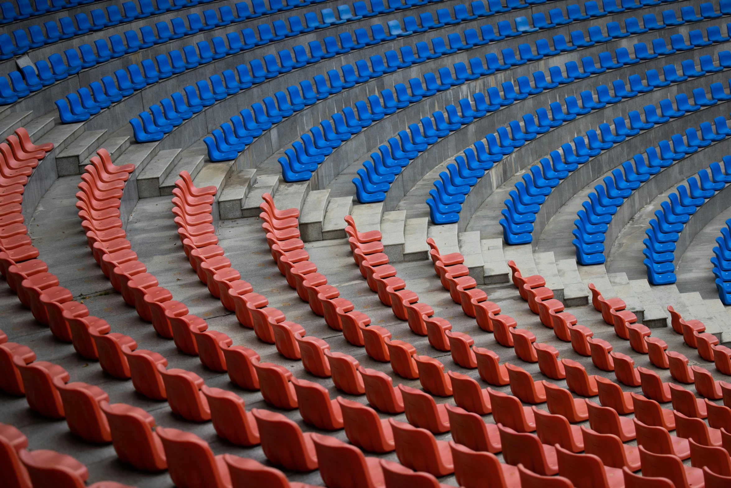 an arena full of seats with the seats in blue and red