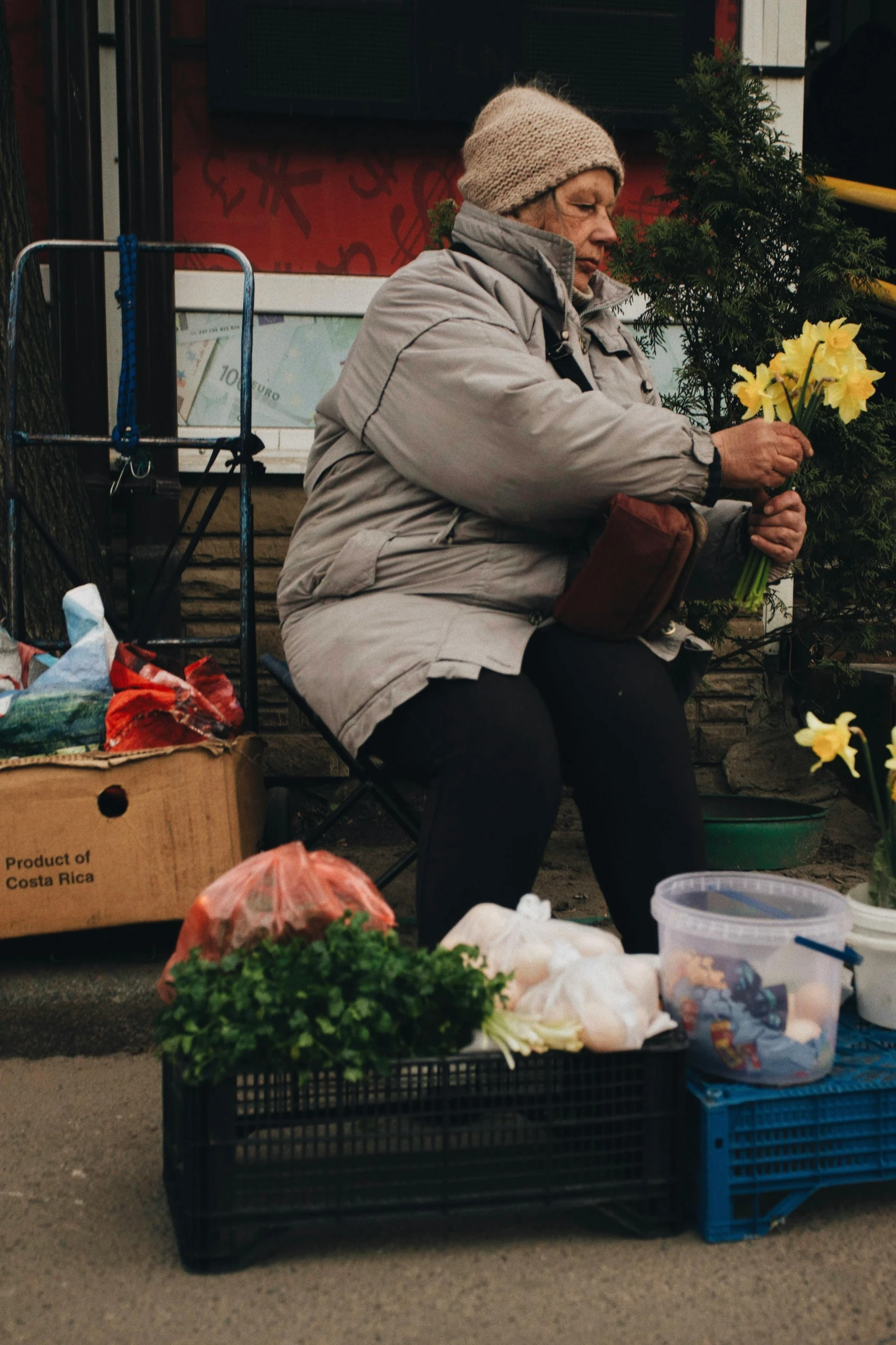 an old woman sitting on a bench with flowers