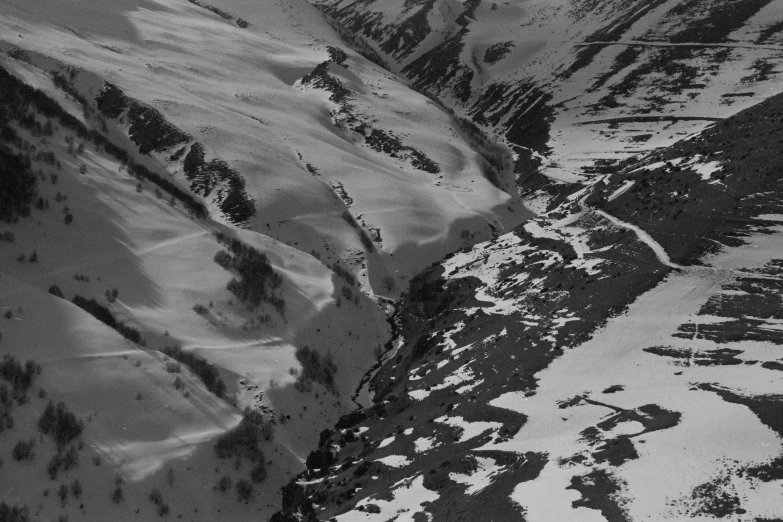 an aerial view from the air, looking down a snowy mountain valley