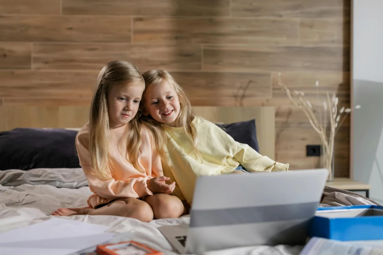 a couple of girls are sitting on the bed