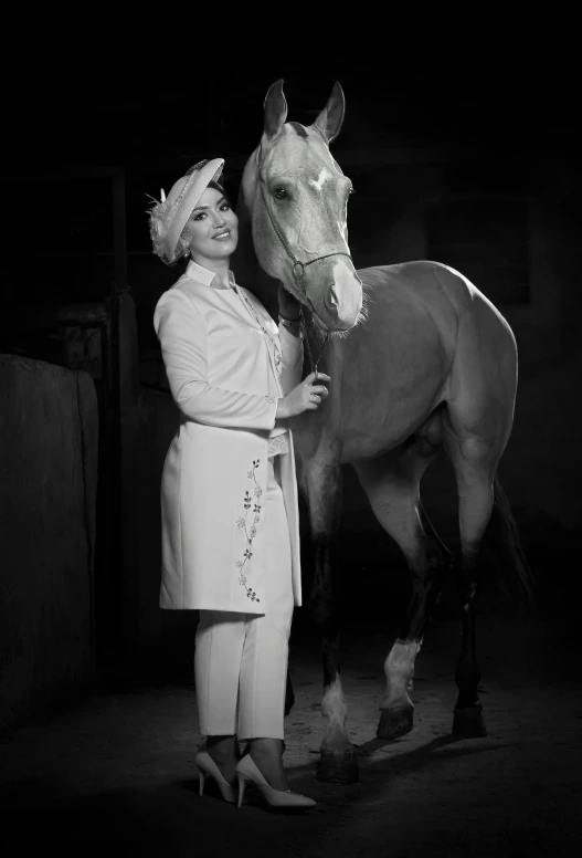 a woman stands next to a horse