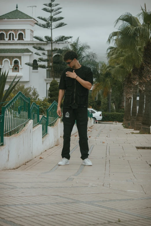 a man standing next to a wall while looking at his cell phone