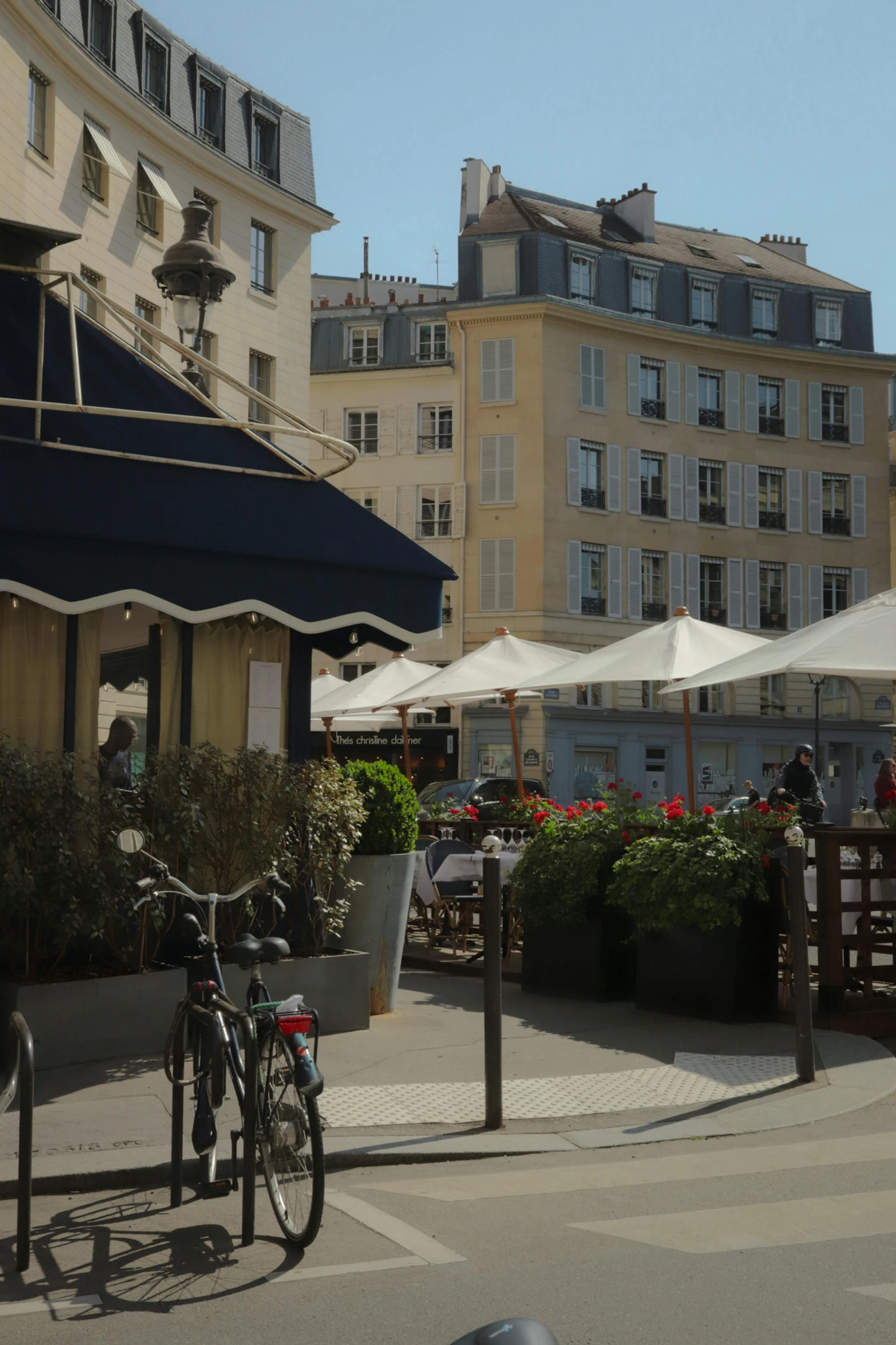 a bike parked outside near many buildings with flower pots