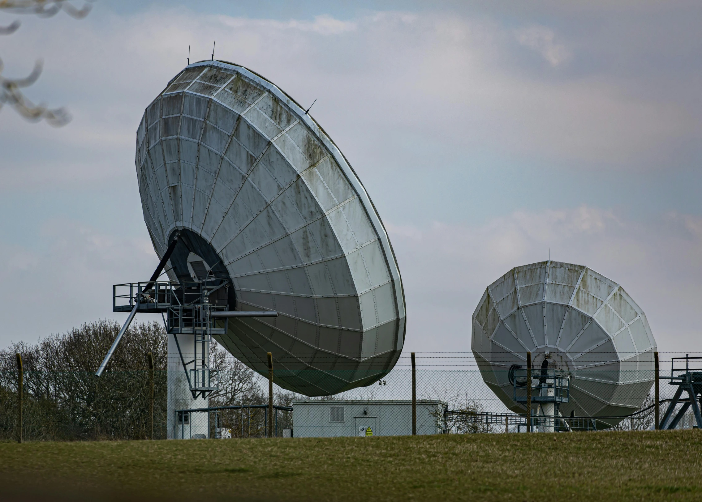 a couple of big antennas sitting on top of a green field