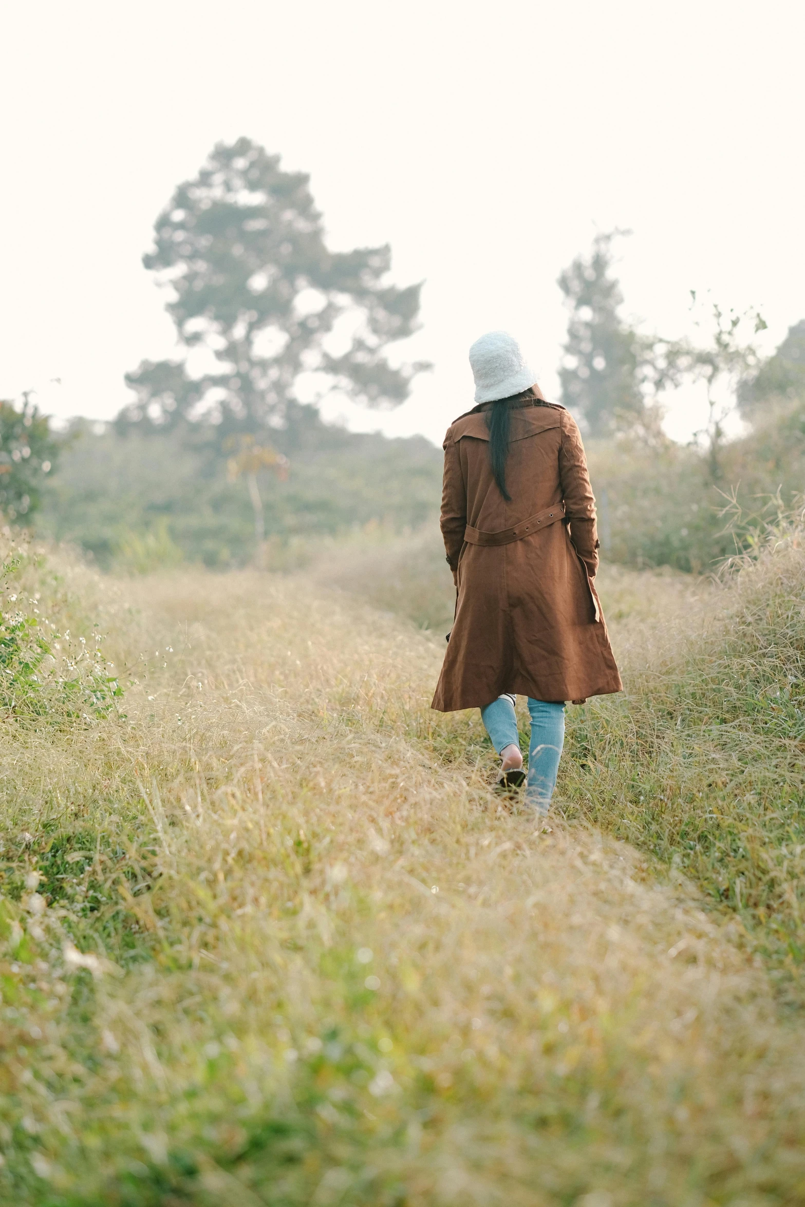 a woman is walking through the grass