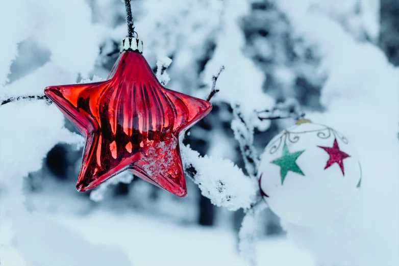 a red glass star ornament on a nch with snow