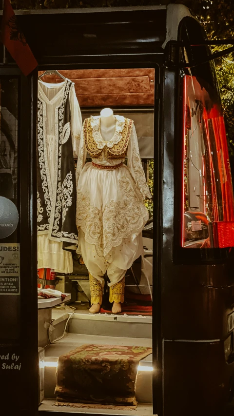 a display case with an old fashion dress and other things