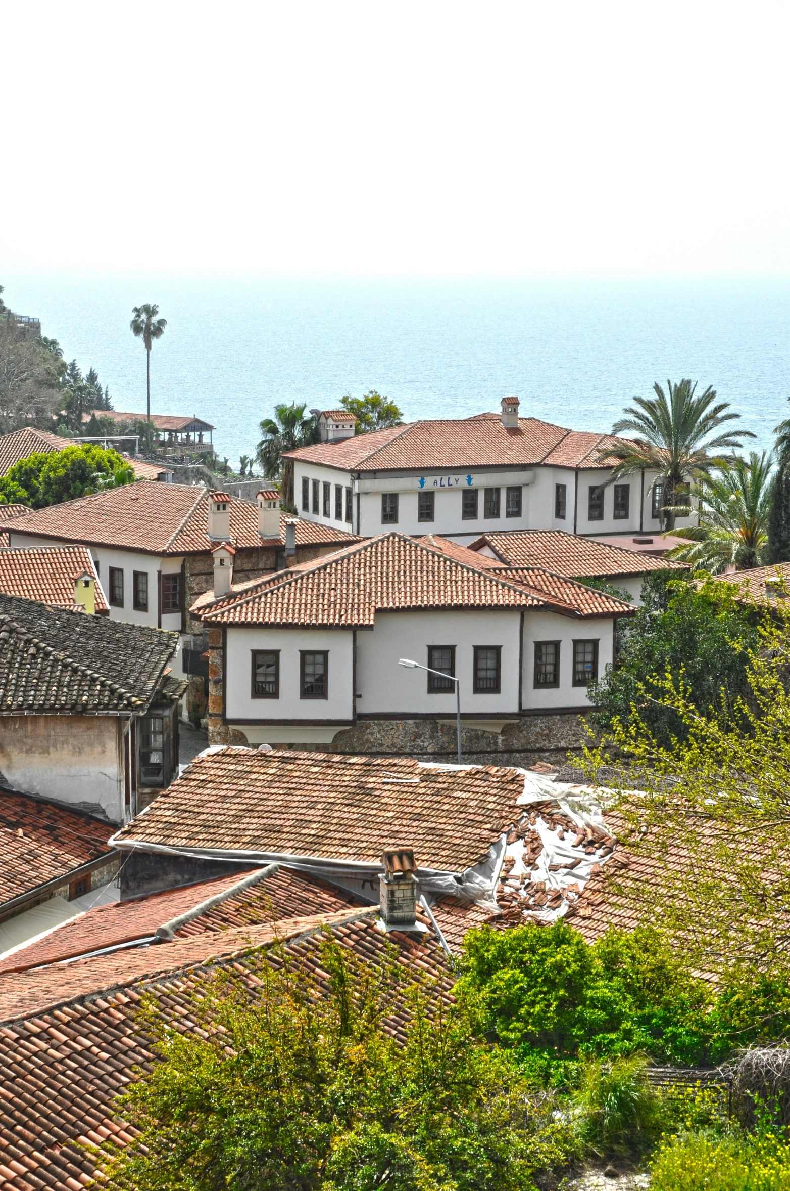 an old building with a few windows and red tiled roofs on a hillside