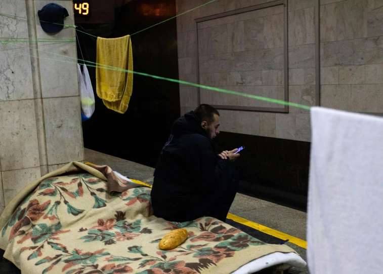 a person sitting on a bed while using a phone