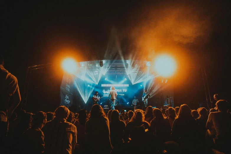 large groups of people watch an outdoor concert