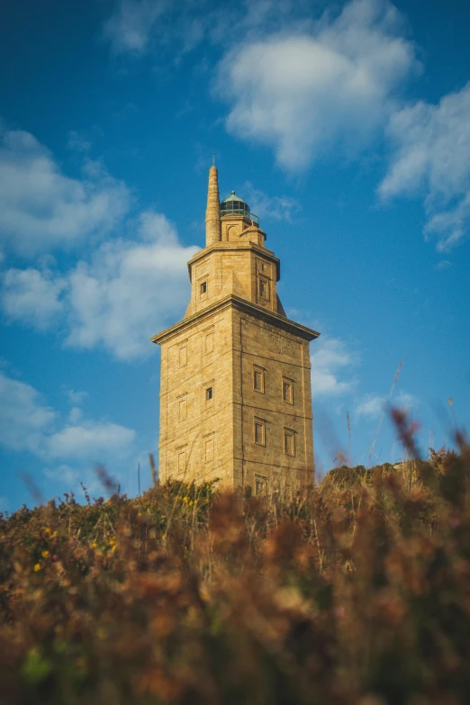 a tall tower sits on top of a hill