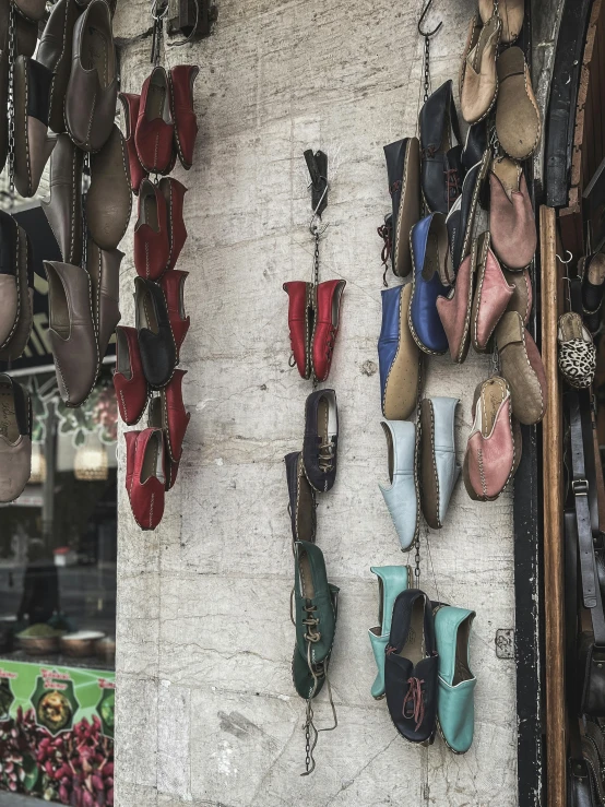 a wall with several pairs of shoes hanging on it