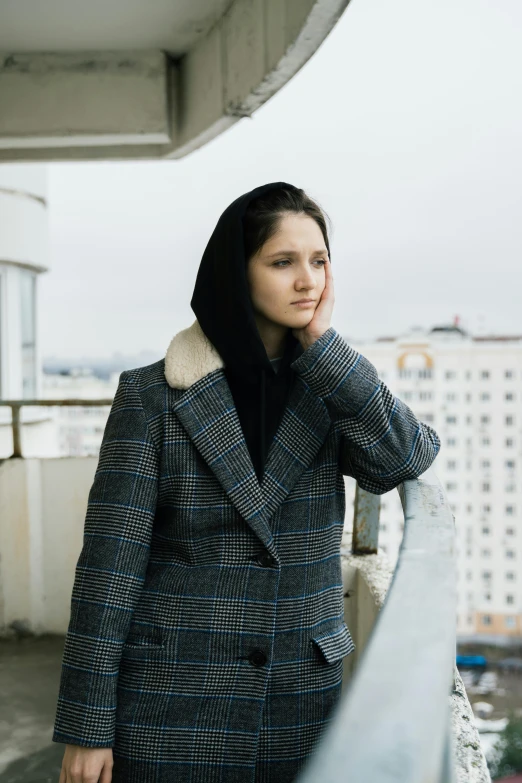 a woman leaning on a railing near a city