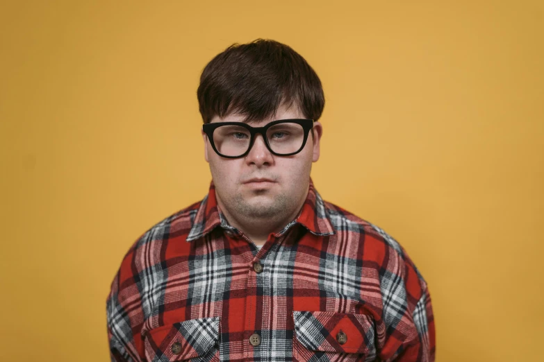 a man wearing a flannel shirt and eyeglasses, posing for a po