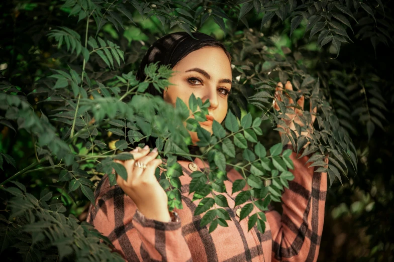 a woman in plaid standing next to some leaves