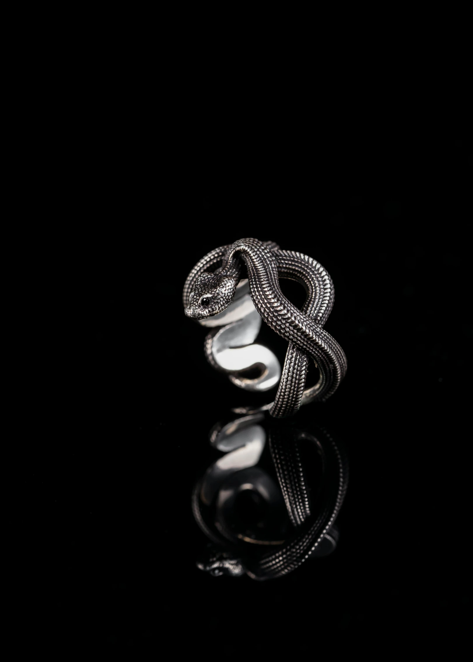 a diamond and silver ring on top of a black surface