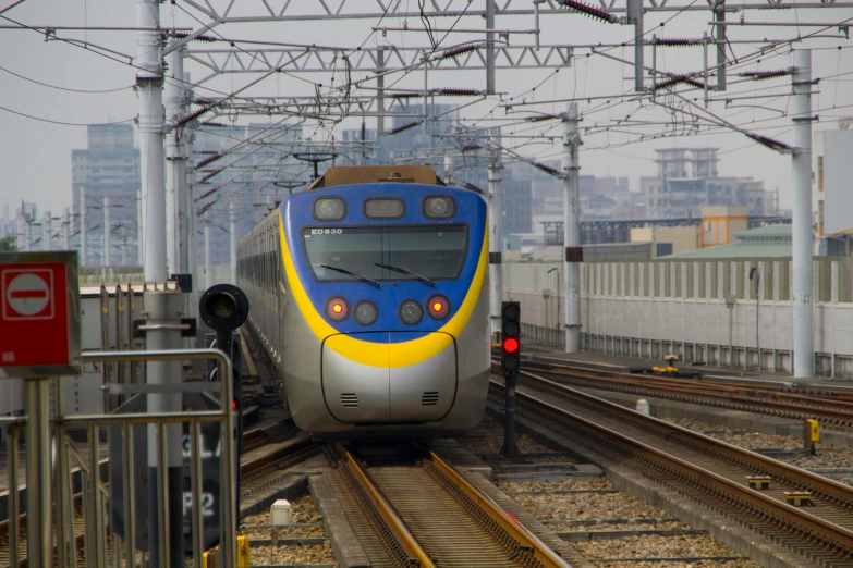 a blue and yellow train traveling down train tracks