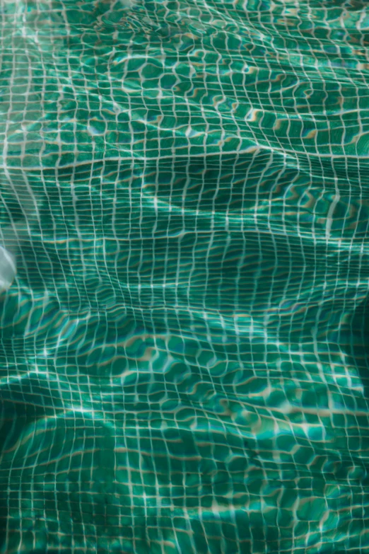 an open laptop computer is placed on the blue pool of water