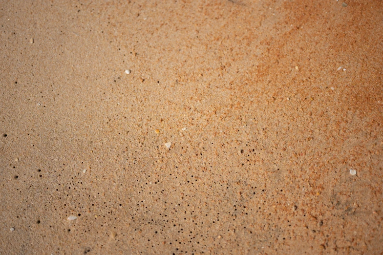 a sand covered floor with little drops of water