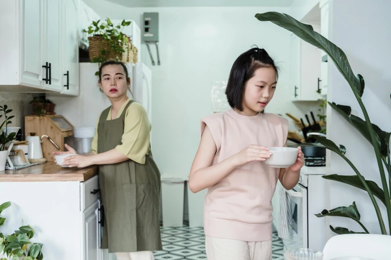 two women in the kitchen with pots and bowls