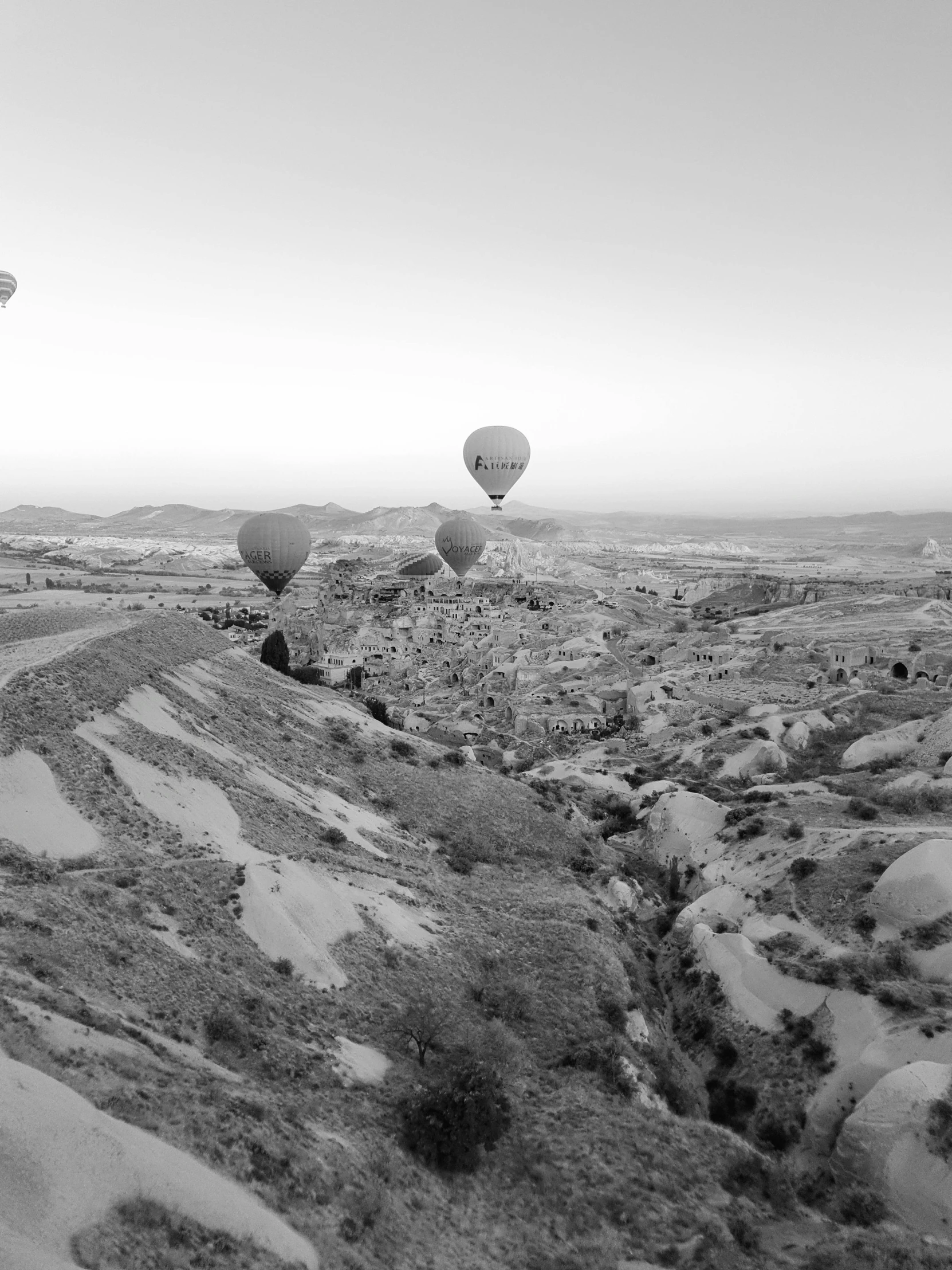 several  air balloons flying in the sky above a desert landscape