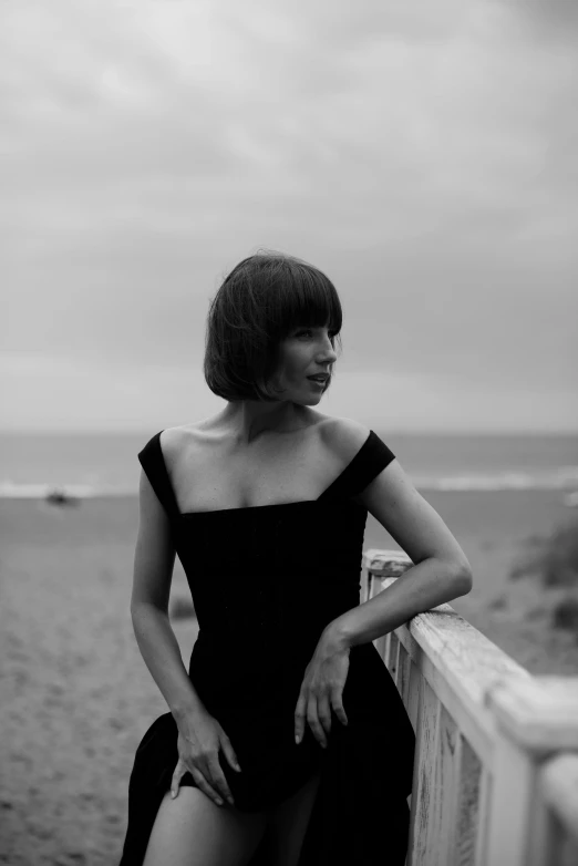 a beautiful young woman sitting on a beach near the ocean