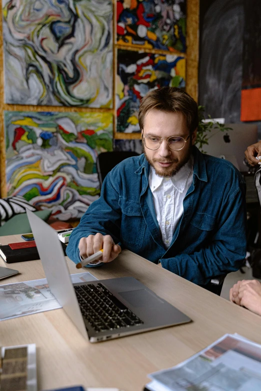 two men at table looking at laptop screen