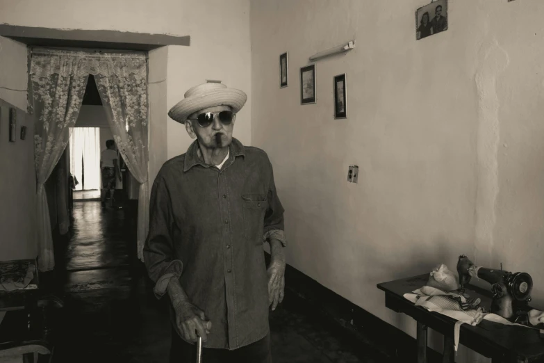a man standing in his house wearing a hat and coat