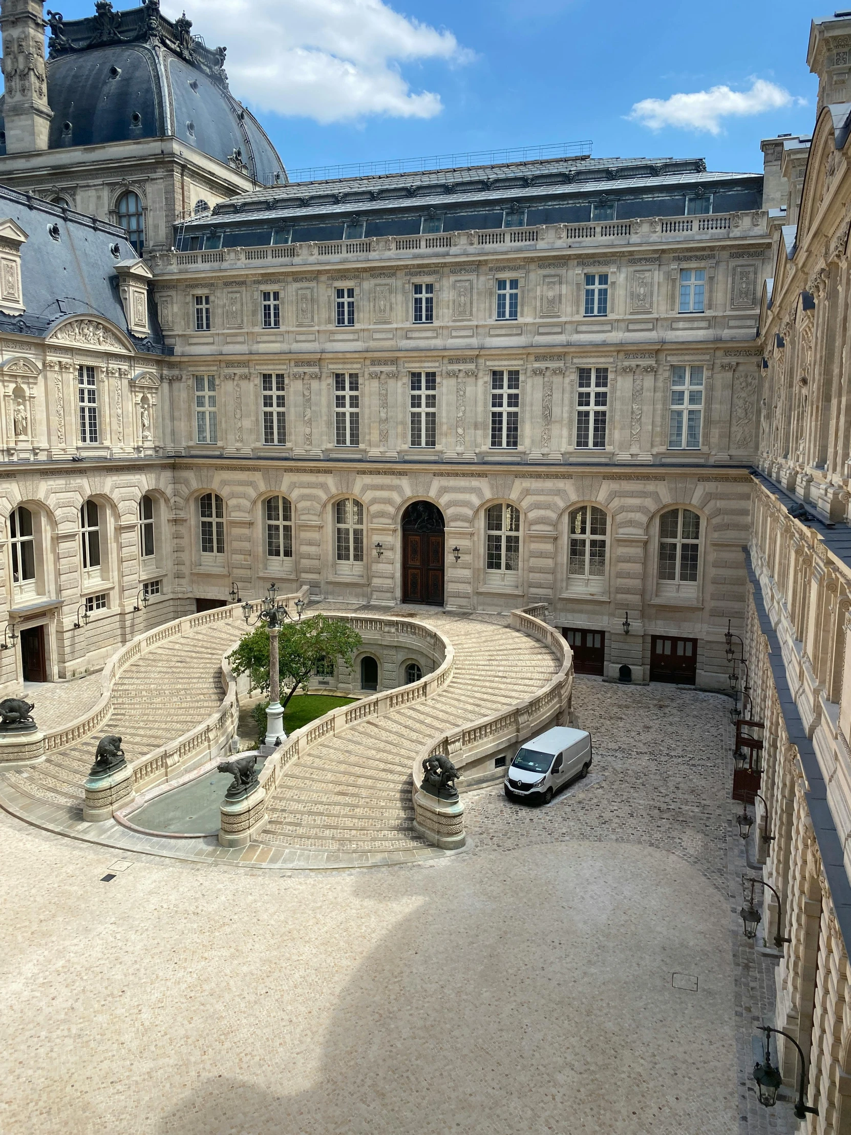 the view of a courtyard in front of a large building