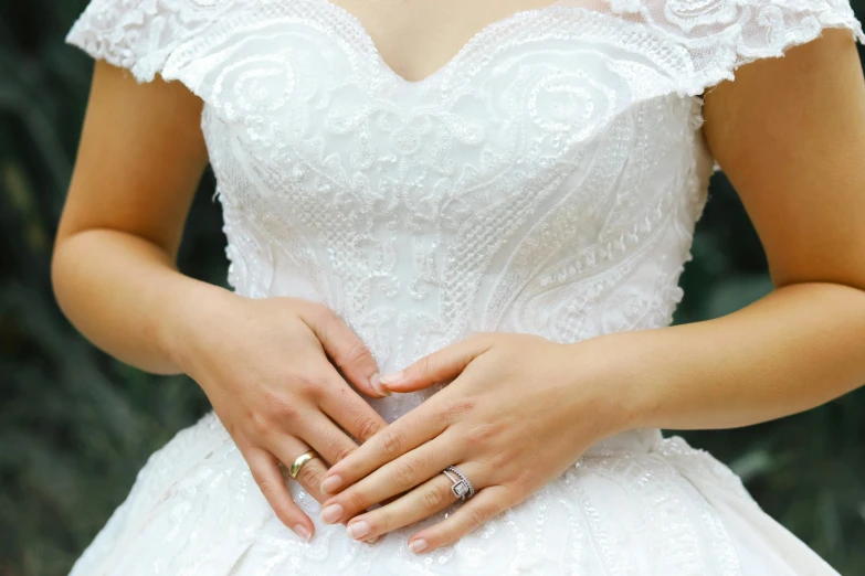 a close up po of a woman's hand in her wedding dress