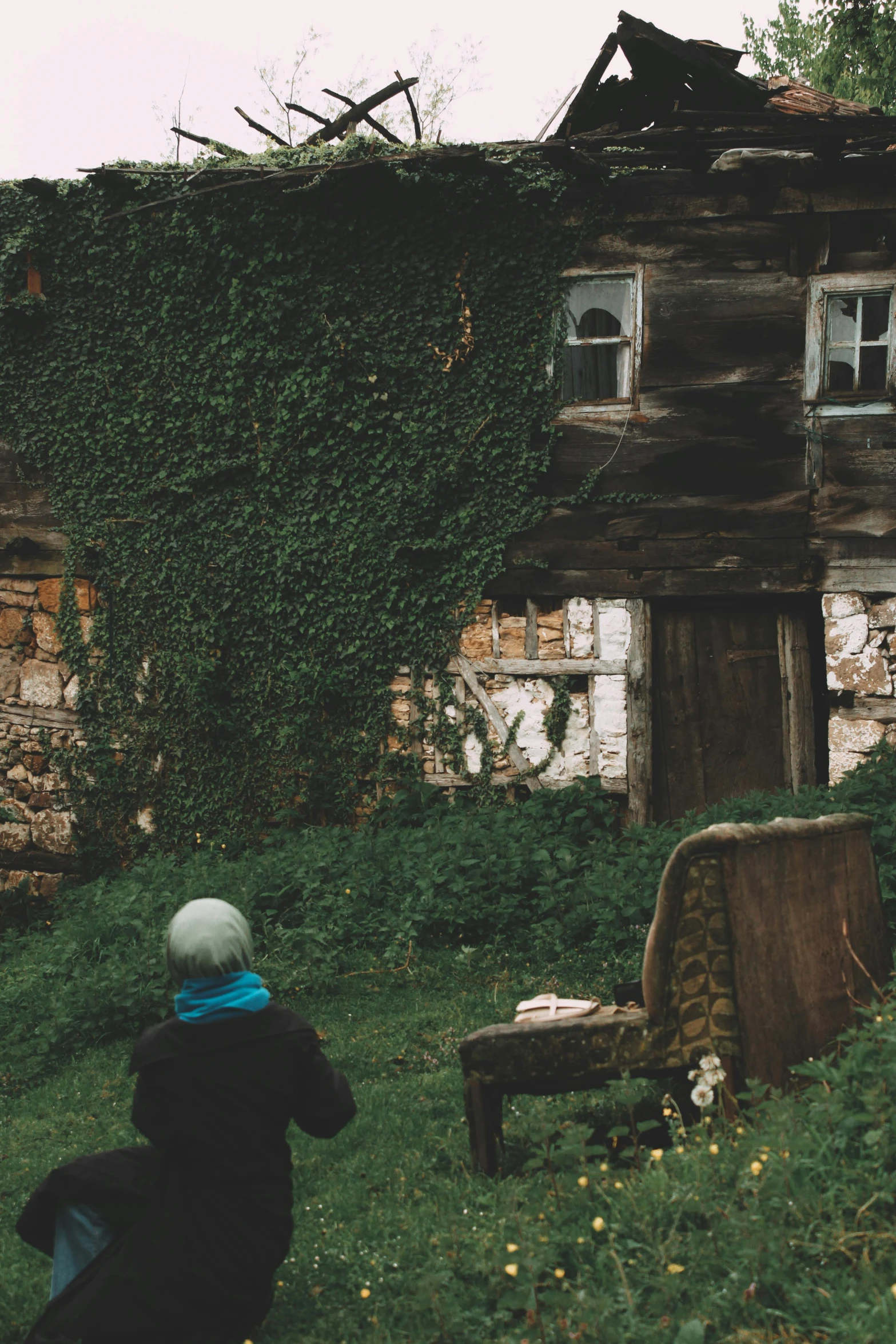 a child looks up at a partially collapsed building