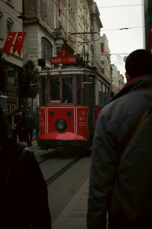 a trolley car traveling down a street past tall buildings