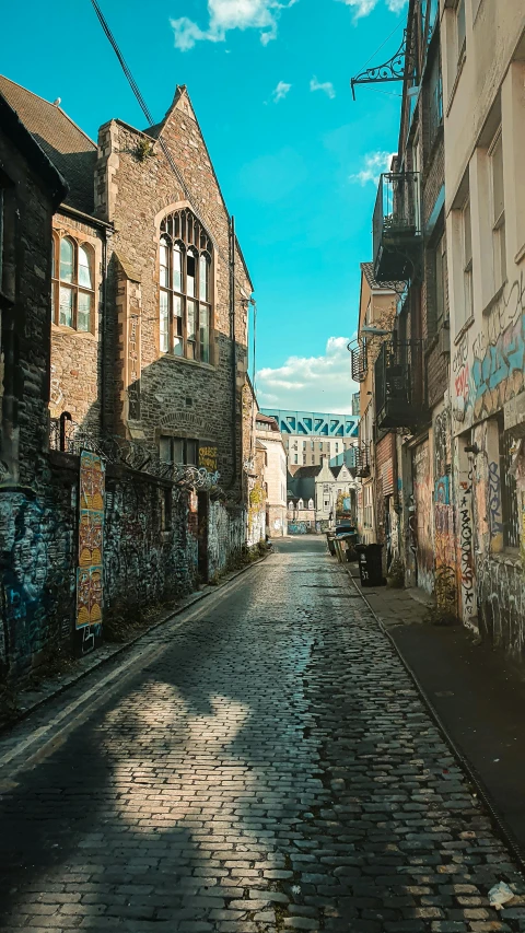 an empty street leading through the middle of some brick buildings