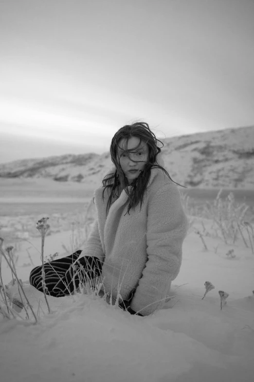 a person sitting in the snow with glasses on