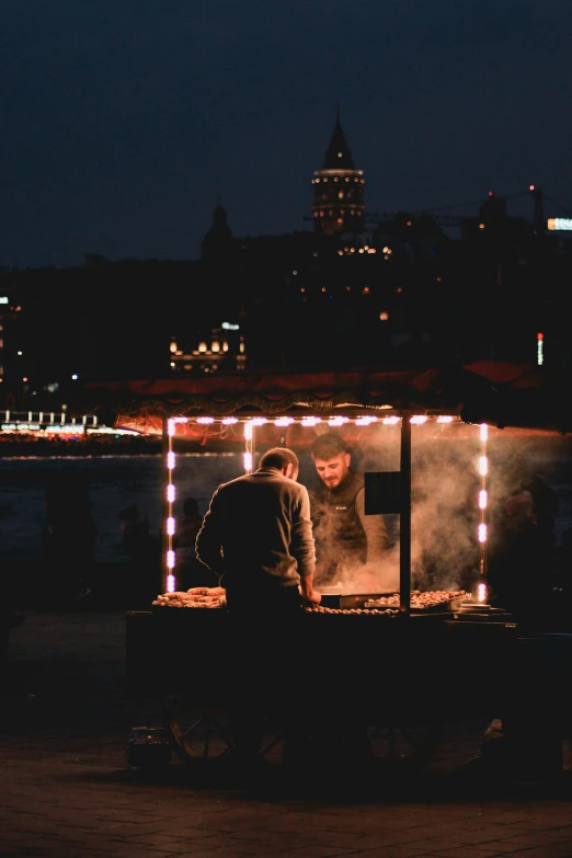 an outdoor cooking area that is lit up at night