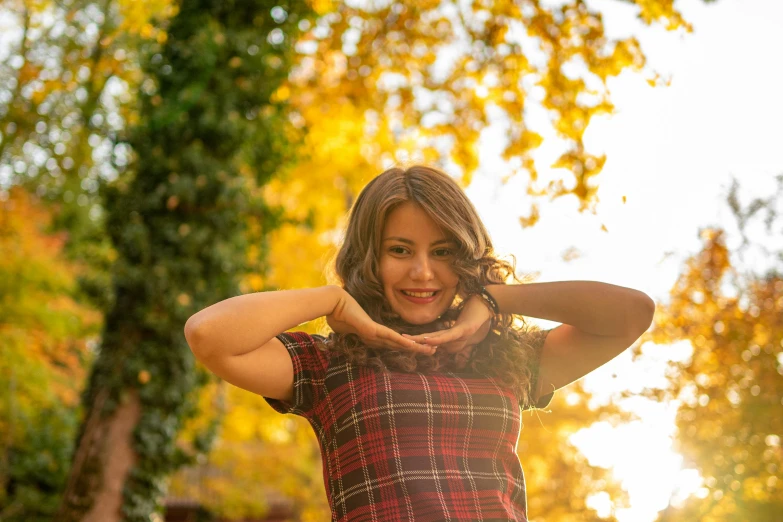 a woman is holding her hands in the air